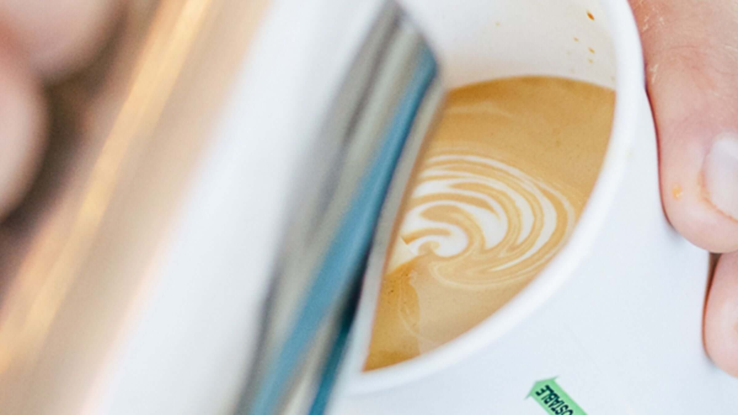 Barista in the office pouring latte art in cup