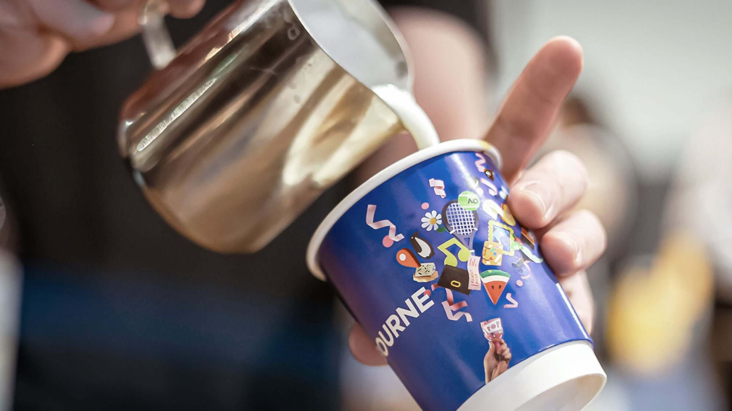 Barista pouring latte art into a takeaway Melbourne coffee cup