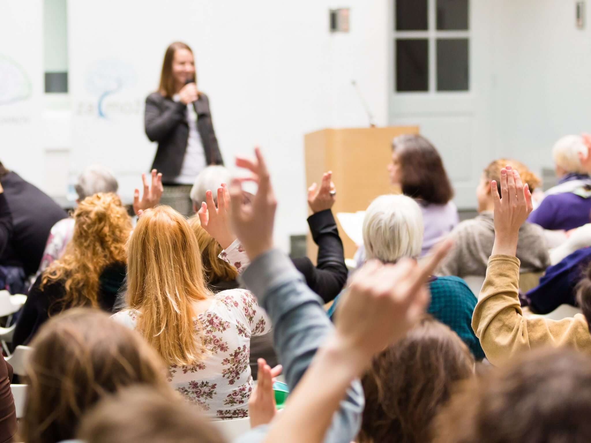 Conference guests with their hands raised high