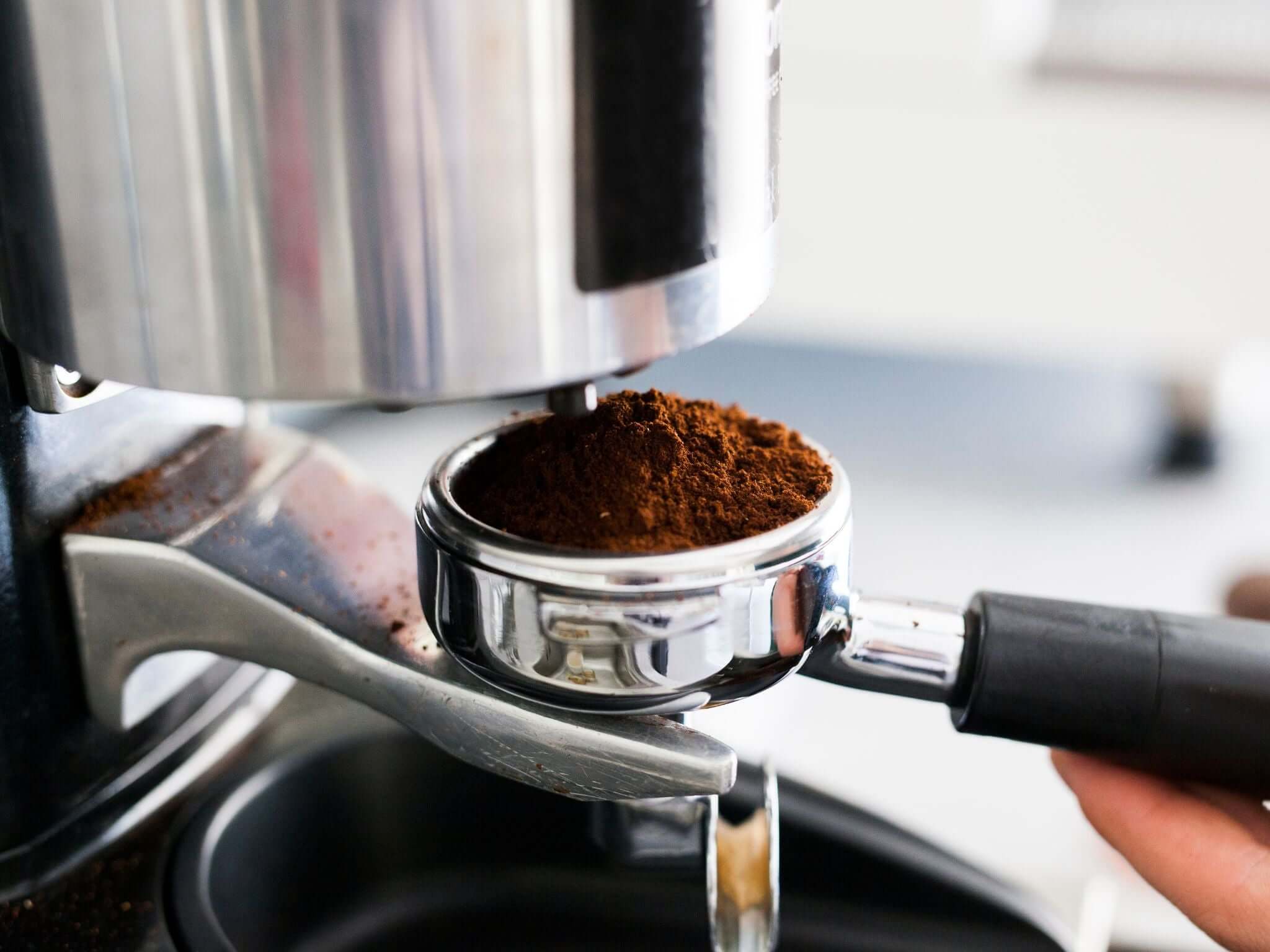 Grinding fresh coffee beans into portafilter