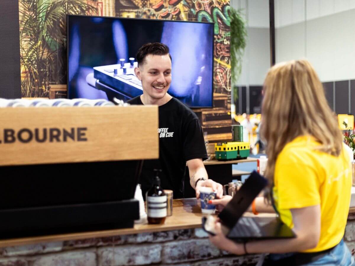 Barista handing tradeshow delegate their coffee