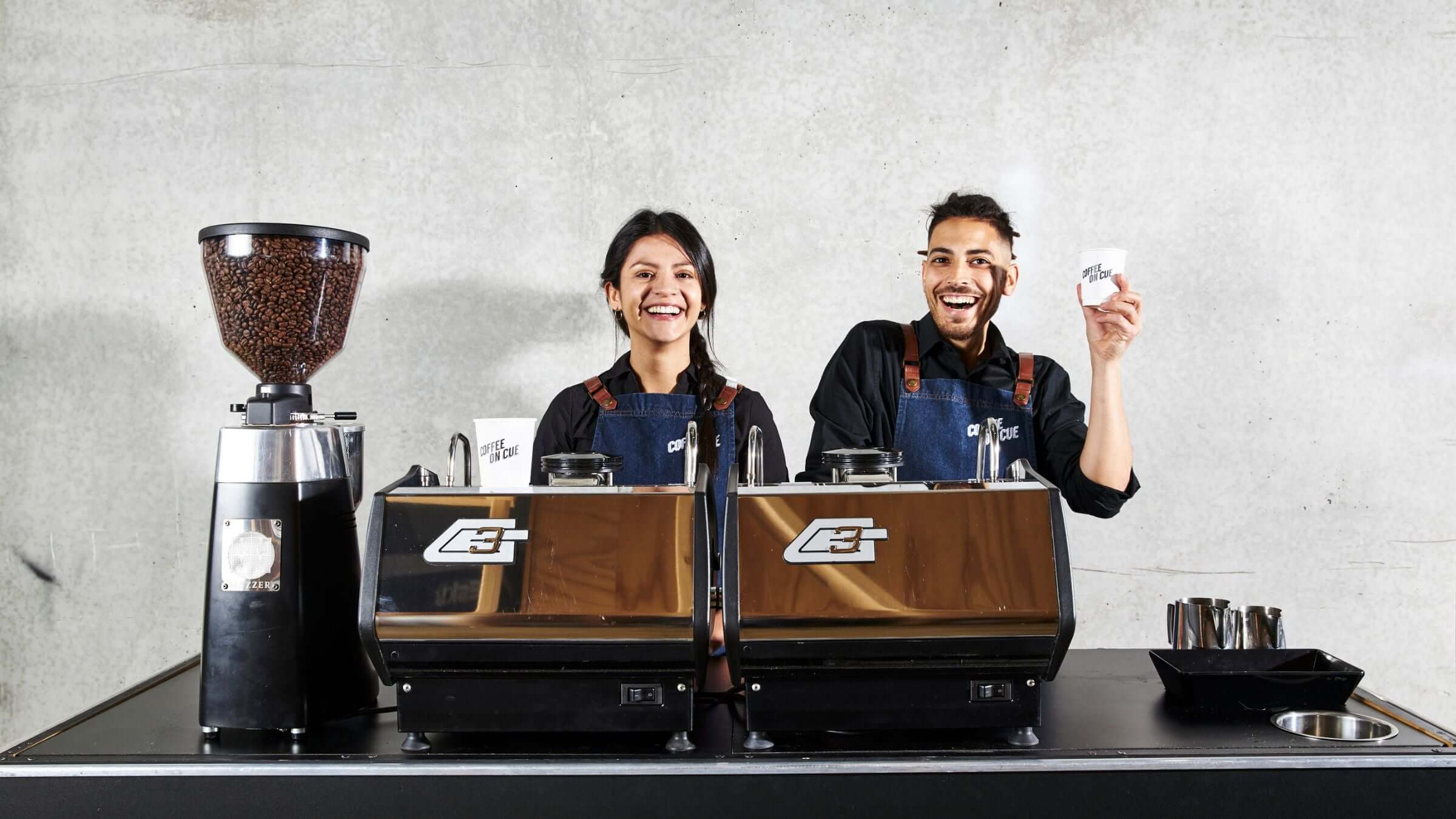 Two baristas working on a twin gs3 coffee cart