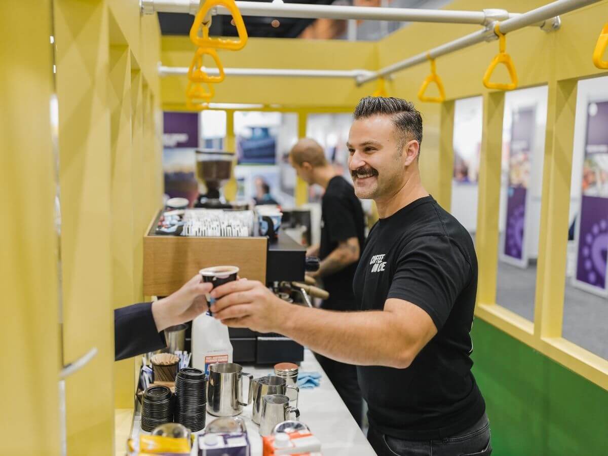 Barista delivering coffee to delegate