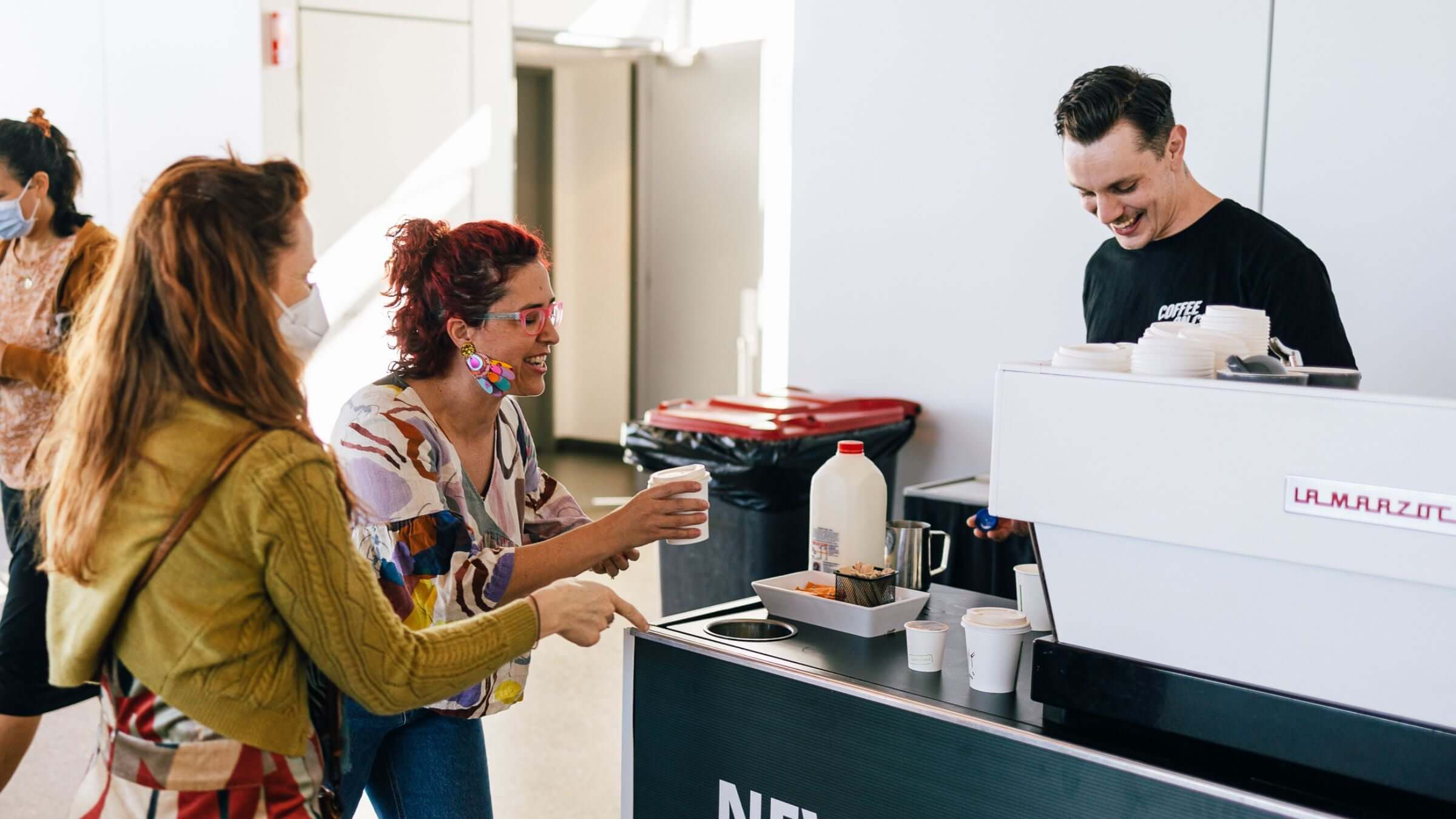 Barista making coffee and serving market attendees