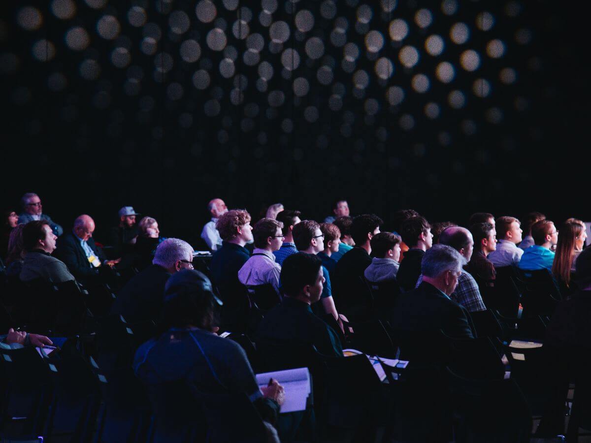 Conference guests sitting taking notes