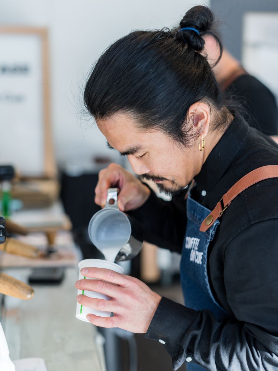 Coffee on Cue in-house barista pouring latte art