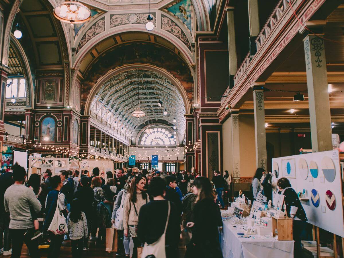 Market stalls and attendees inside venue space