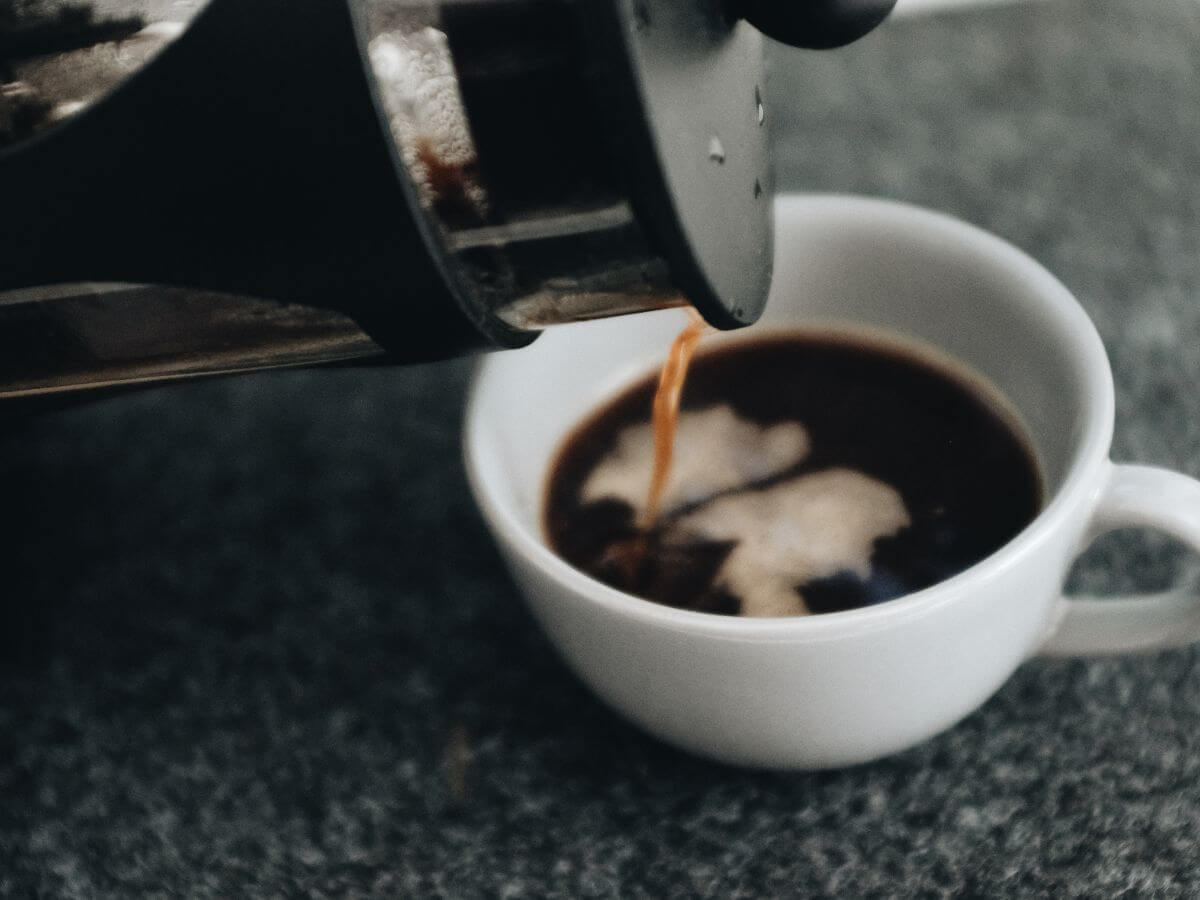 Coffee being poured from plunger to cup