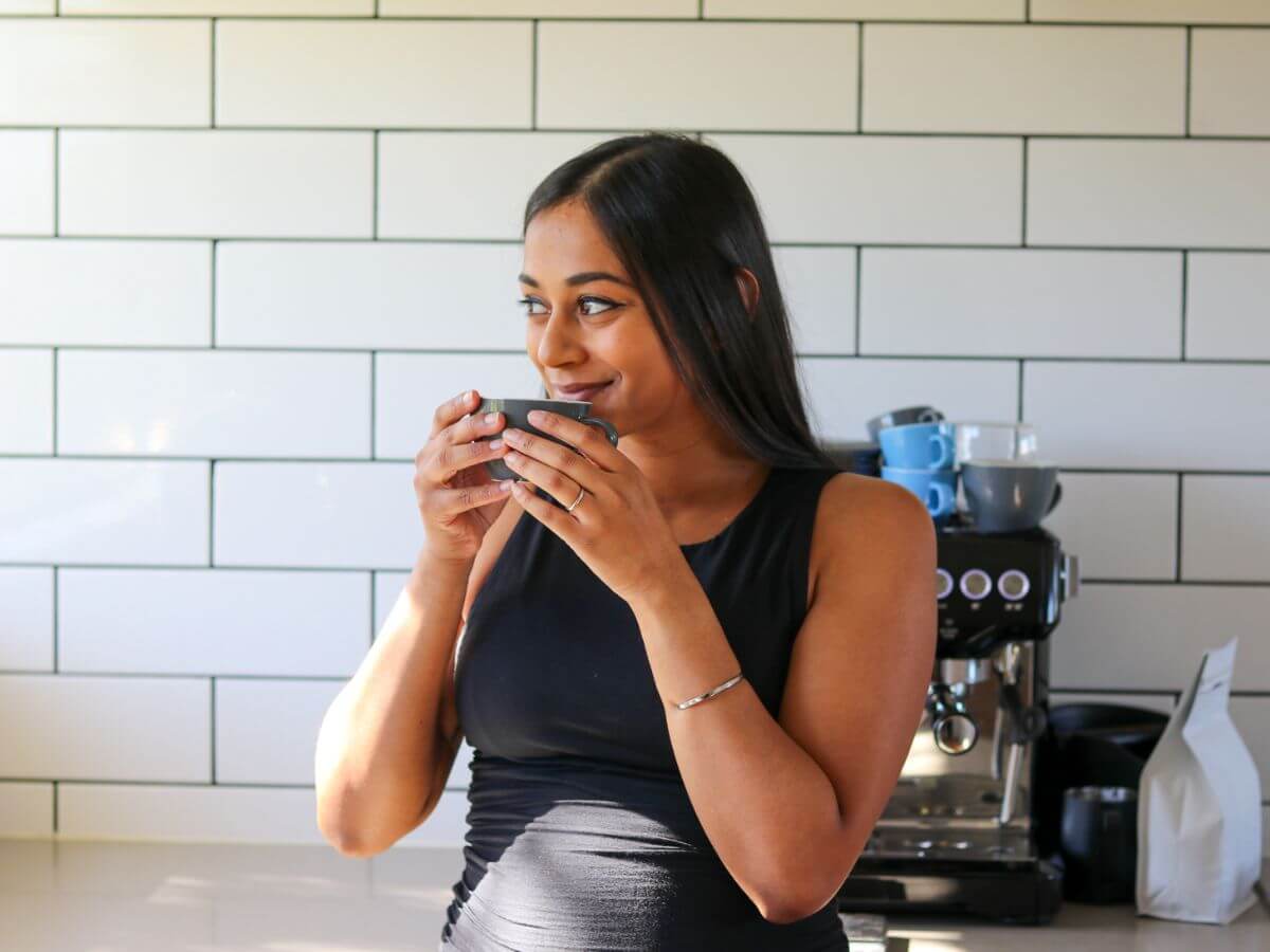 Woman drinking coffee in kitchen at home