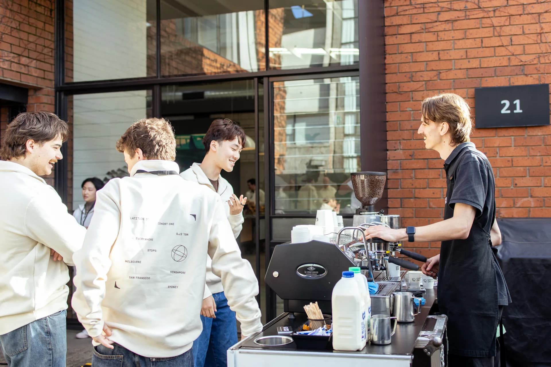 A Coffee on Cue barista taking an order from a group of guests at an outdoor courtyard cart
