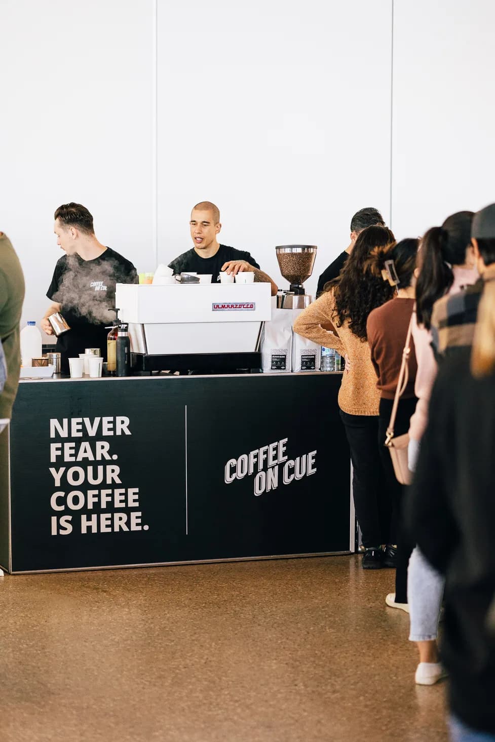 A barista steaming milk with a real queue of delegates waiting