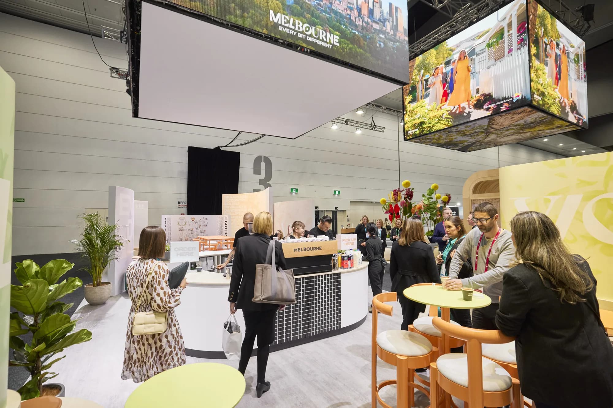 A branded Coffee on Cue coffee cart with baristas serving a busy crowd at a corporate event