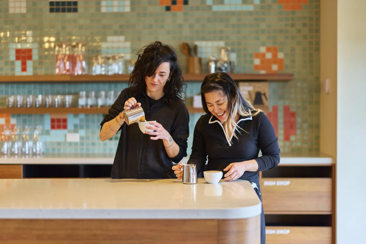 A barista at the corporate office bar against the tiled wall