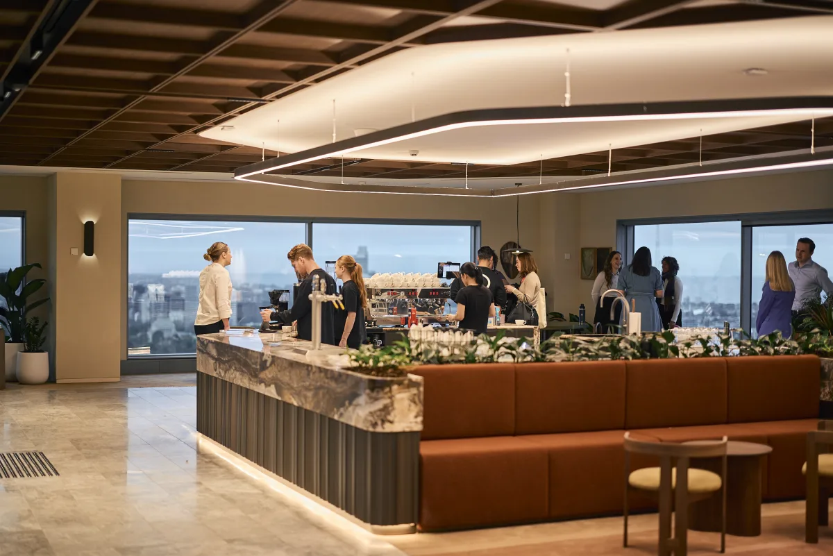 The JLL 101 Collins bar, guests along it and the city beyond