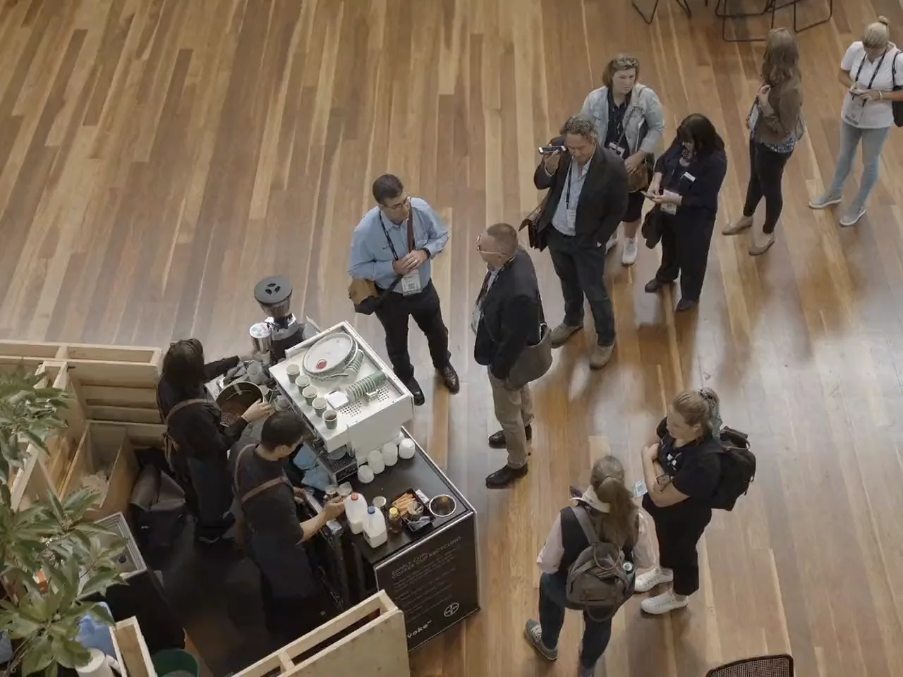 Overhead view of two Coffee on Cue baristas serving conference guests at a coffee cart