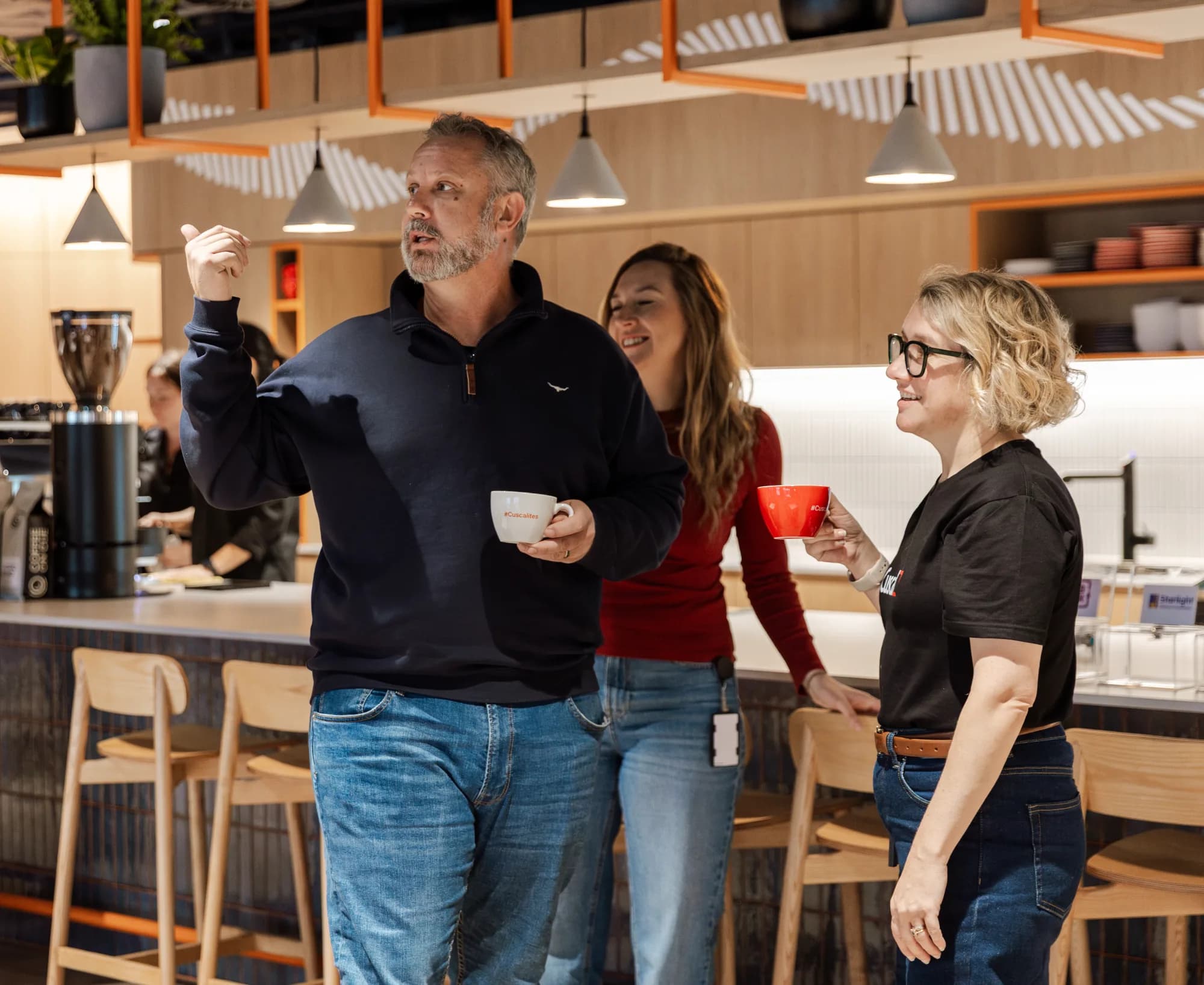 Three colleagues talking over coffee at the Cuscal Sydney workplace bar