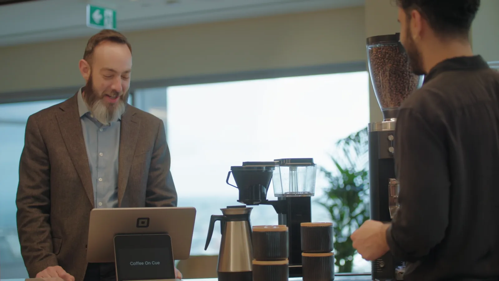 A Coffee on Cue in-house barista serving in an office