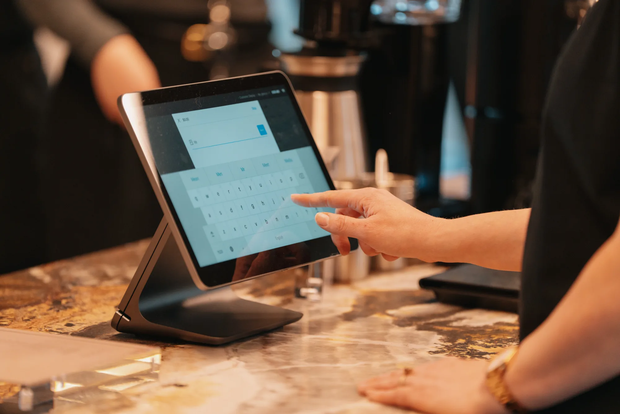A colleague entering their name on the Coffee on Cue ordering tablet at the JLL 101 Collins bar