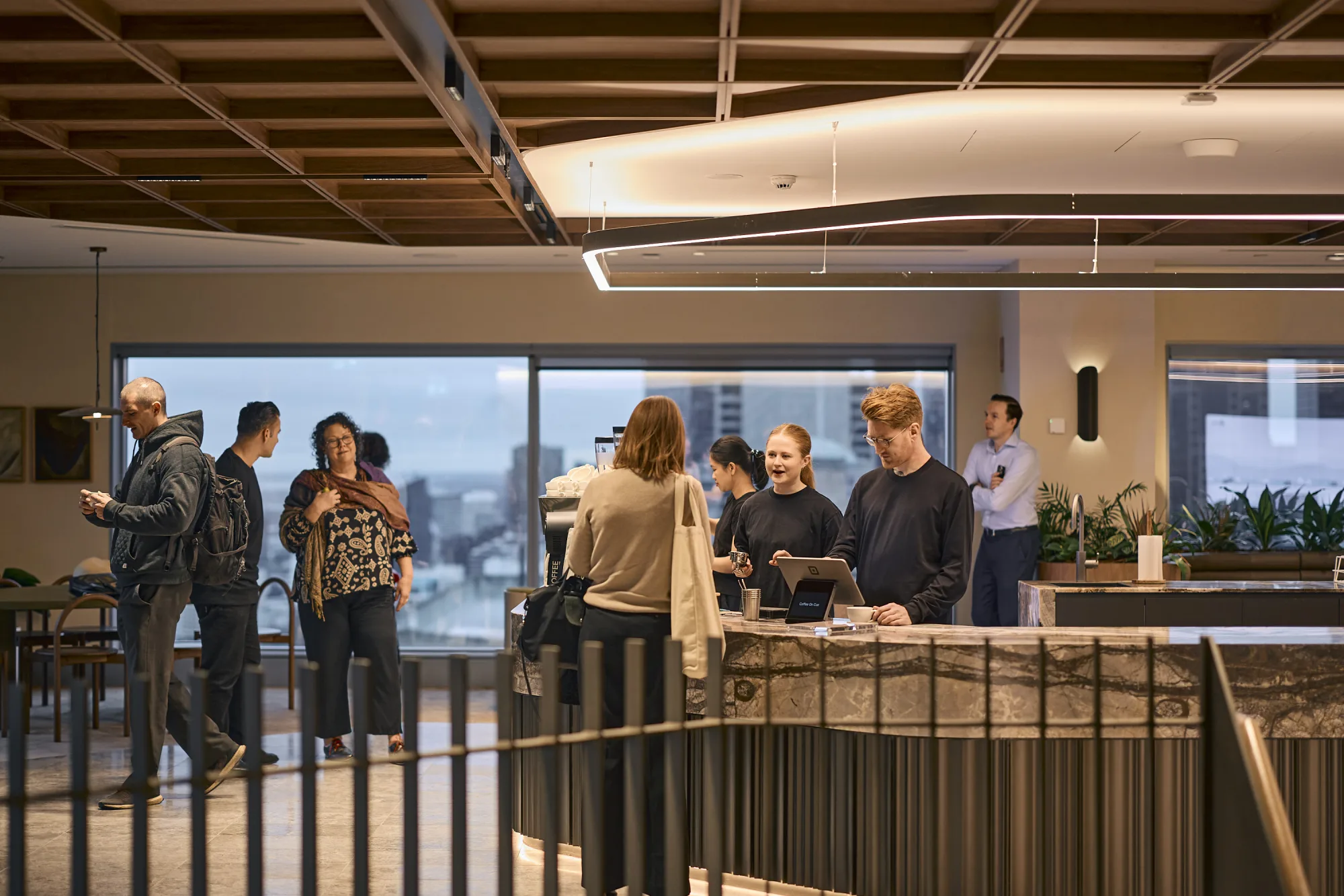Colleagues gathered at the Coffee on Cue bar at JLL 101 Collins, seen across the level