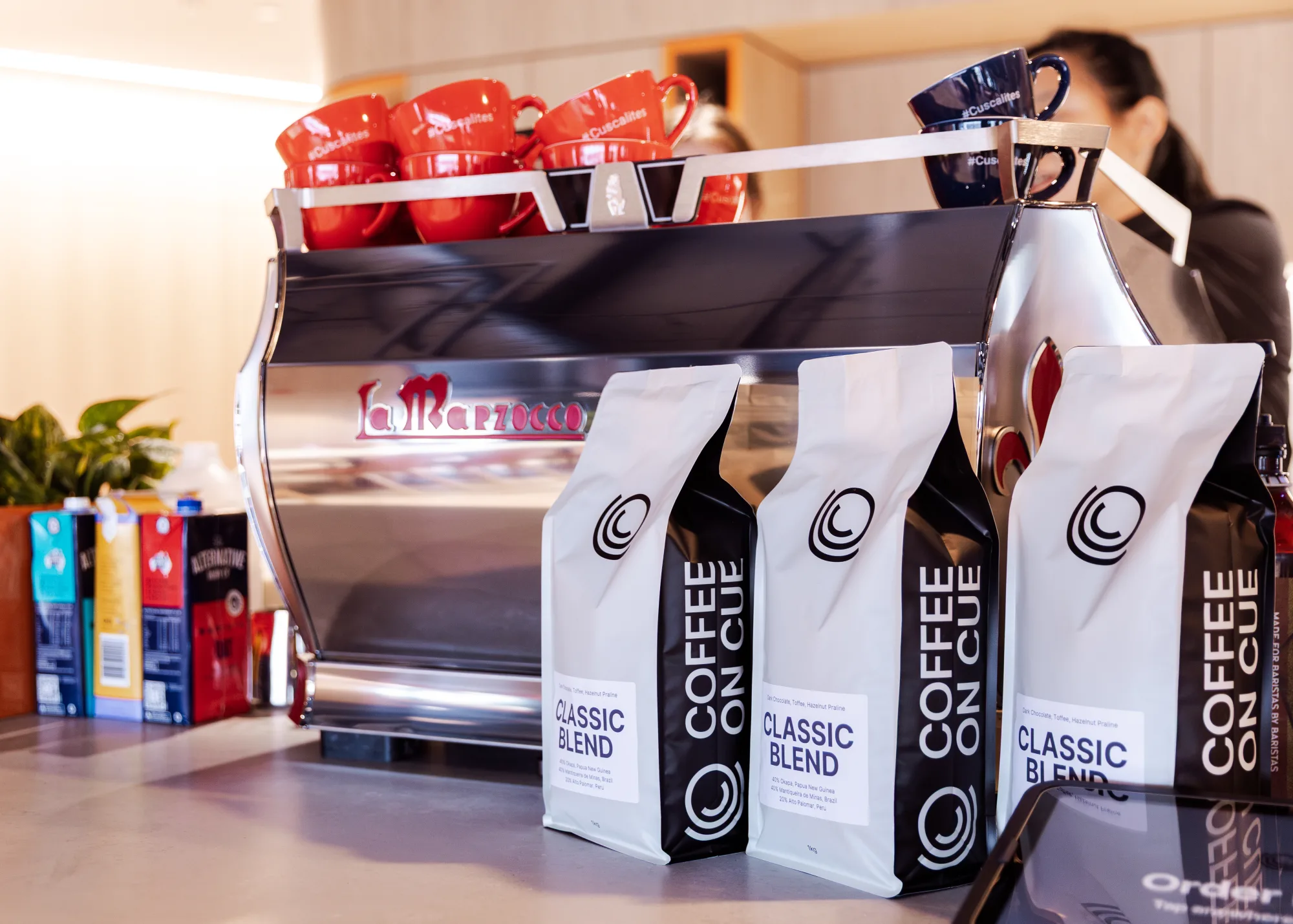 A La Marzocco espresso machine with Coffee on Cue coffee bags and branded mugs