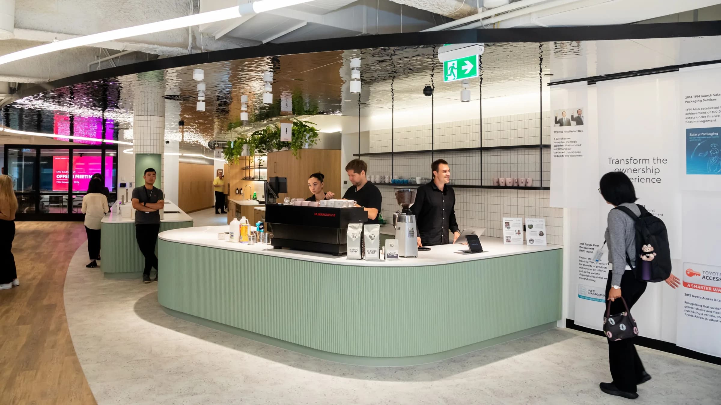 The Coffee on Cue in-house coffee bar at Toyota Finance in Sydney, with baristas serving staff at the curved cafe counter
