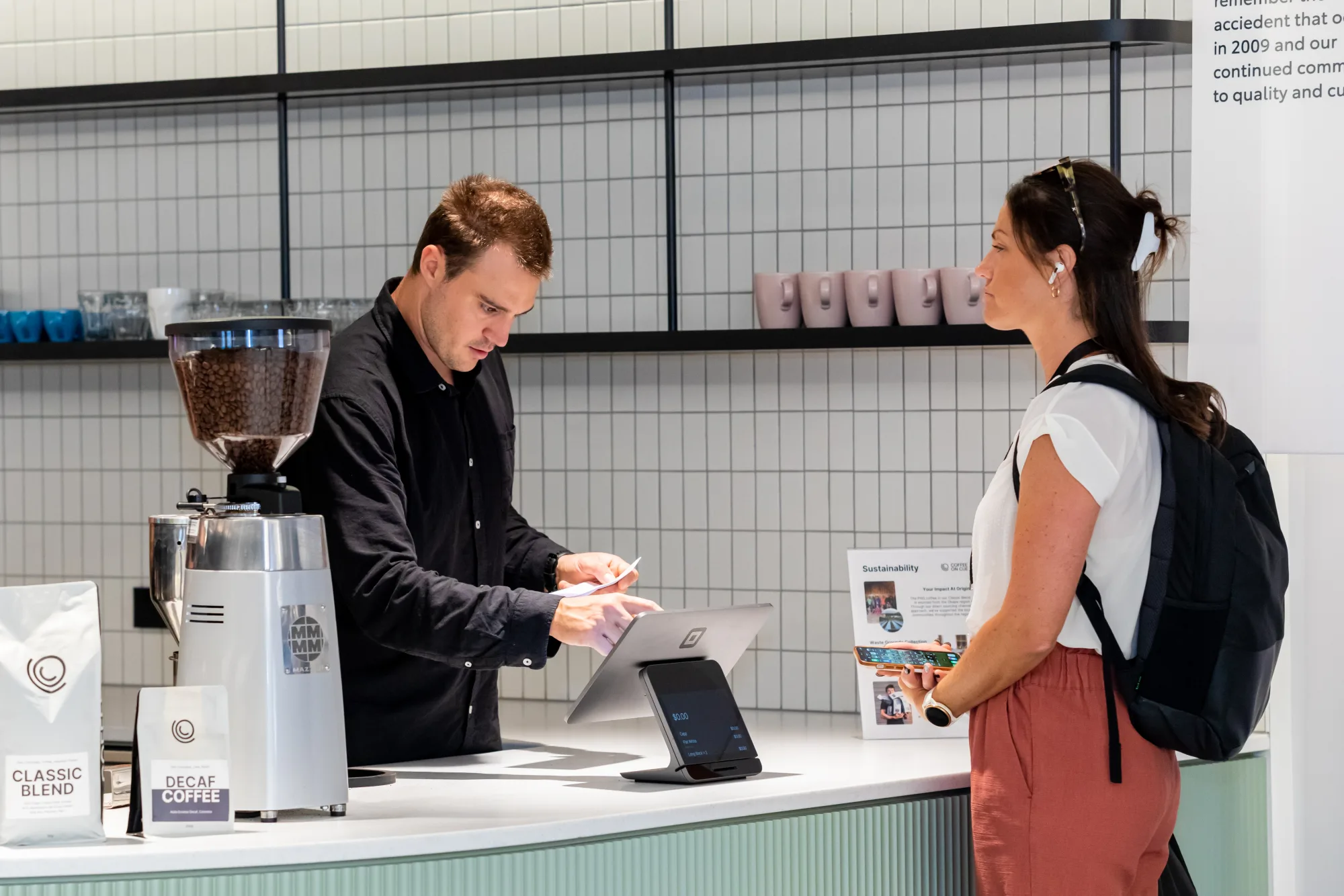 A colleague being served at the Toyota Financial Services counter beside the Coffee on Cue ordering tablet