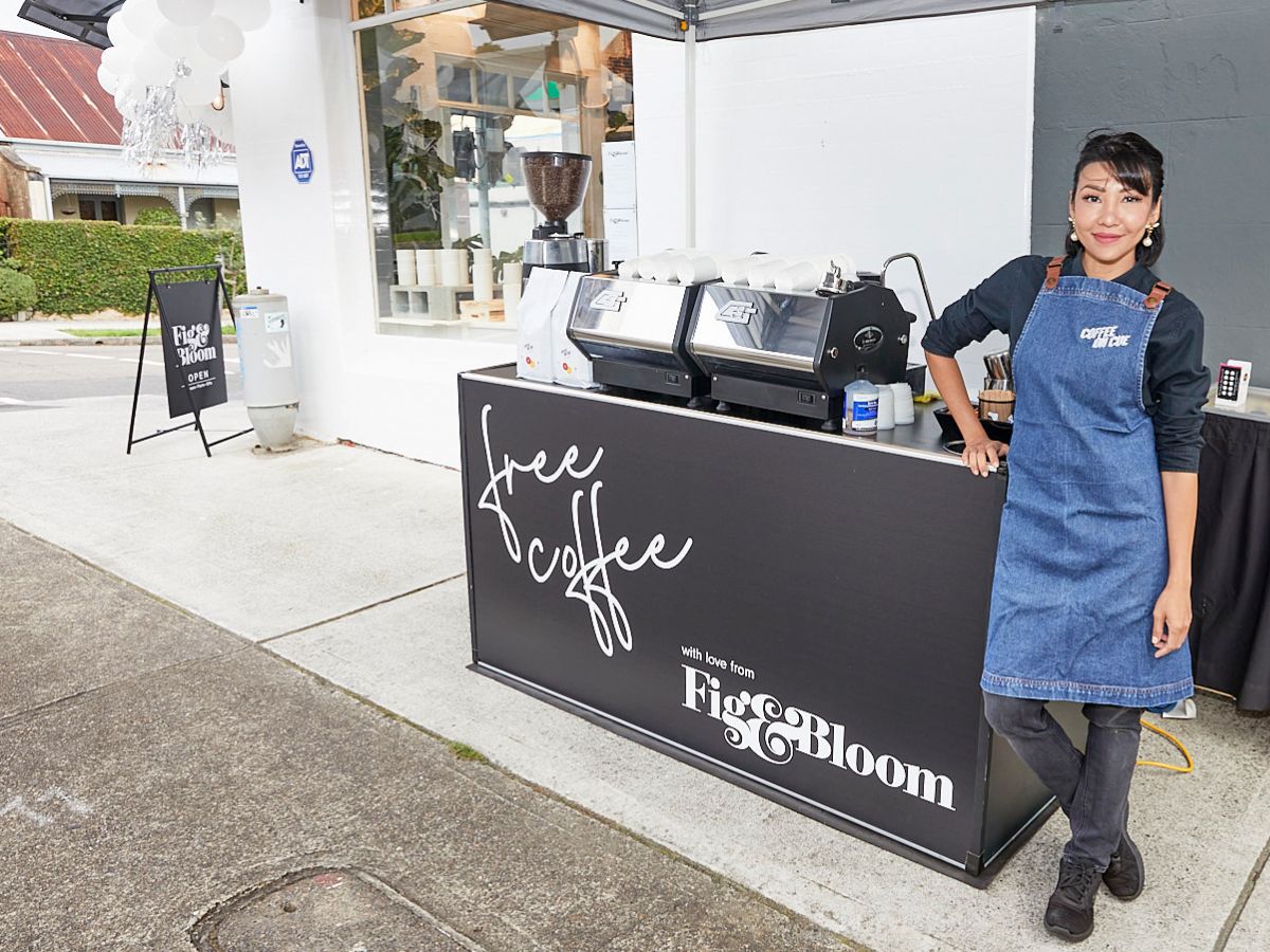 Coffee on Cue barista standing next to branded coffee cart in Sydney at Fig and Bloom retail store activation