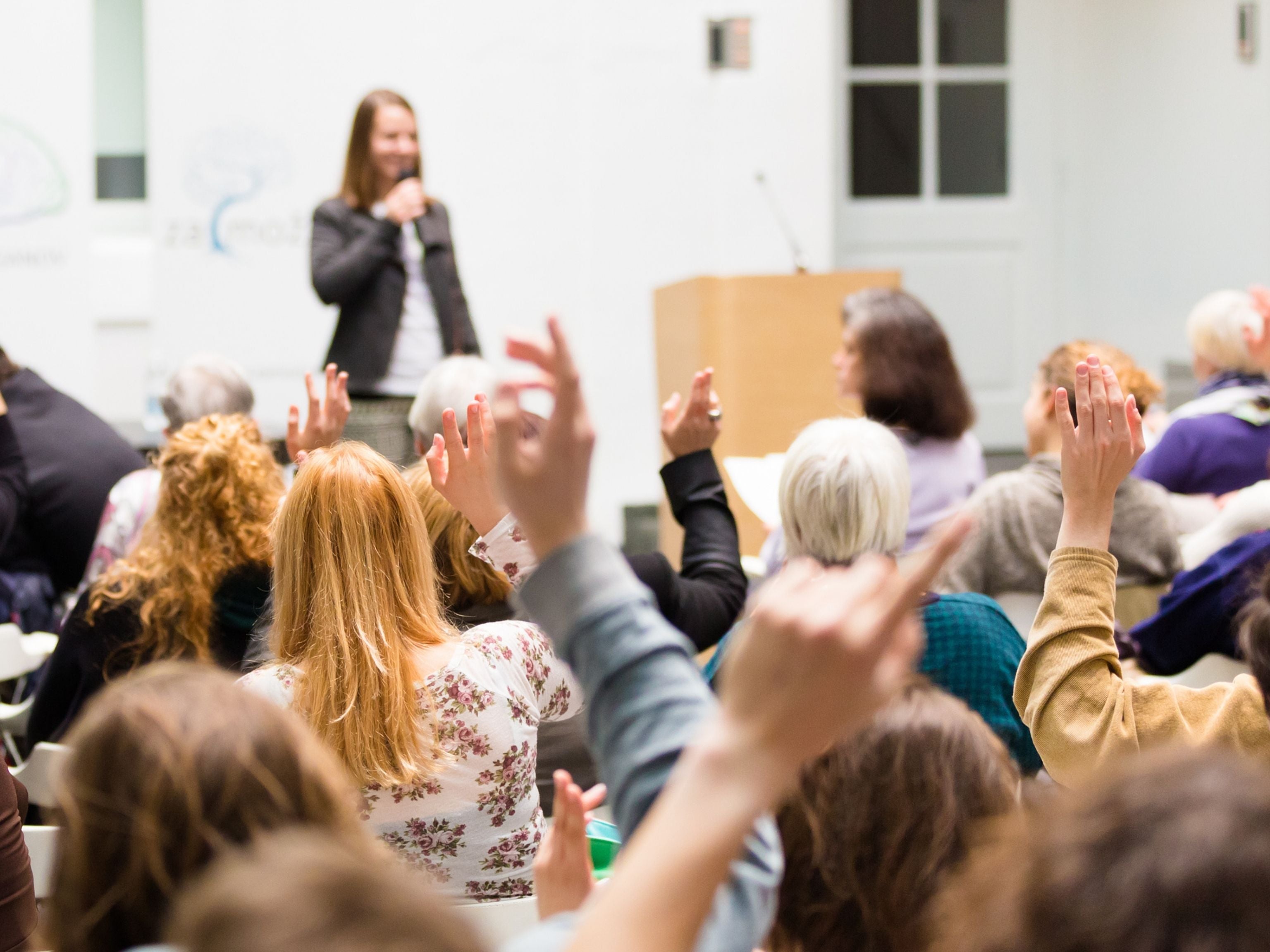 Conference guests with their hands raised high