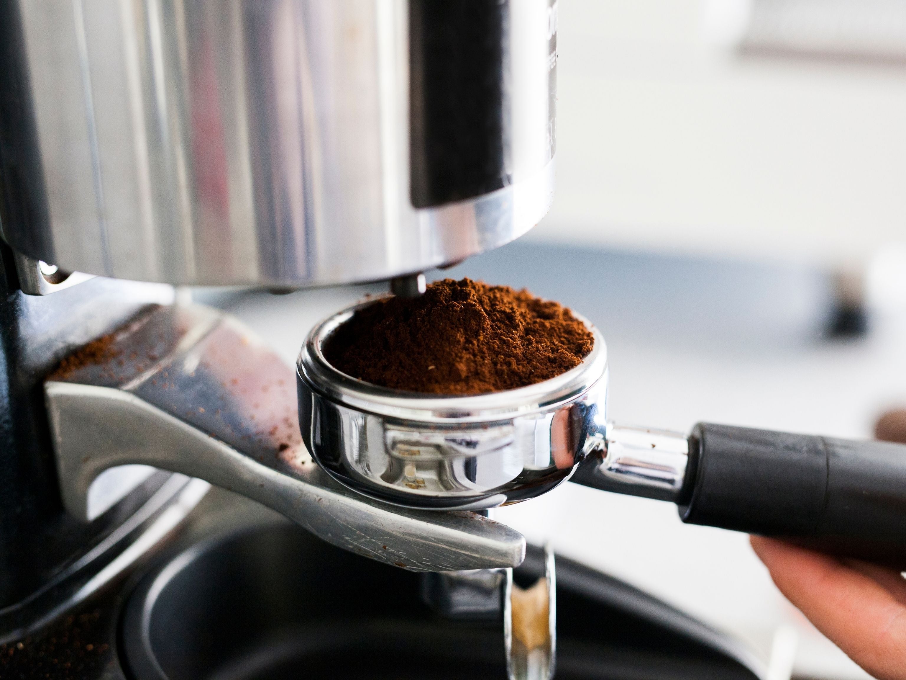 Grinding fresh coffee beans into portafilter