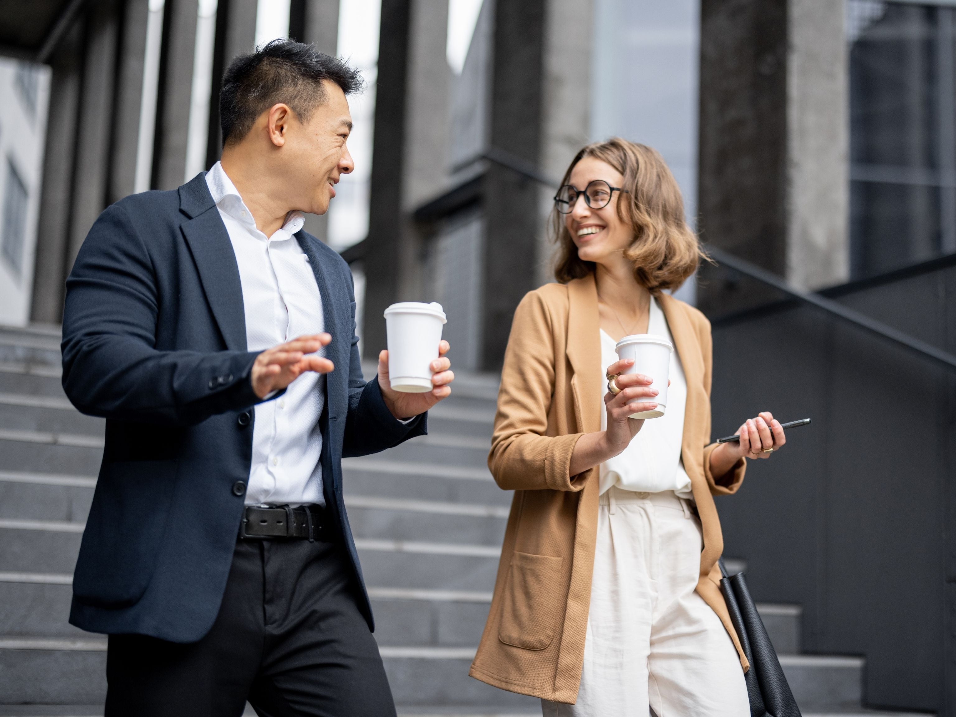 Two colleagues with their takeaway coffees
