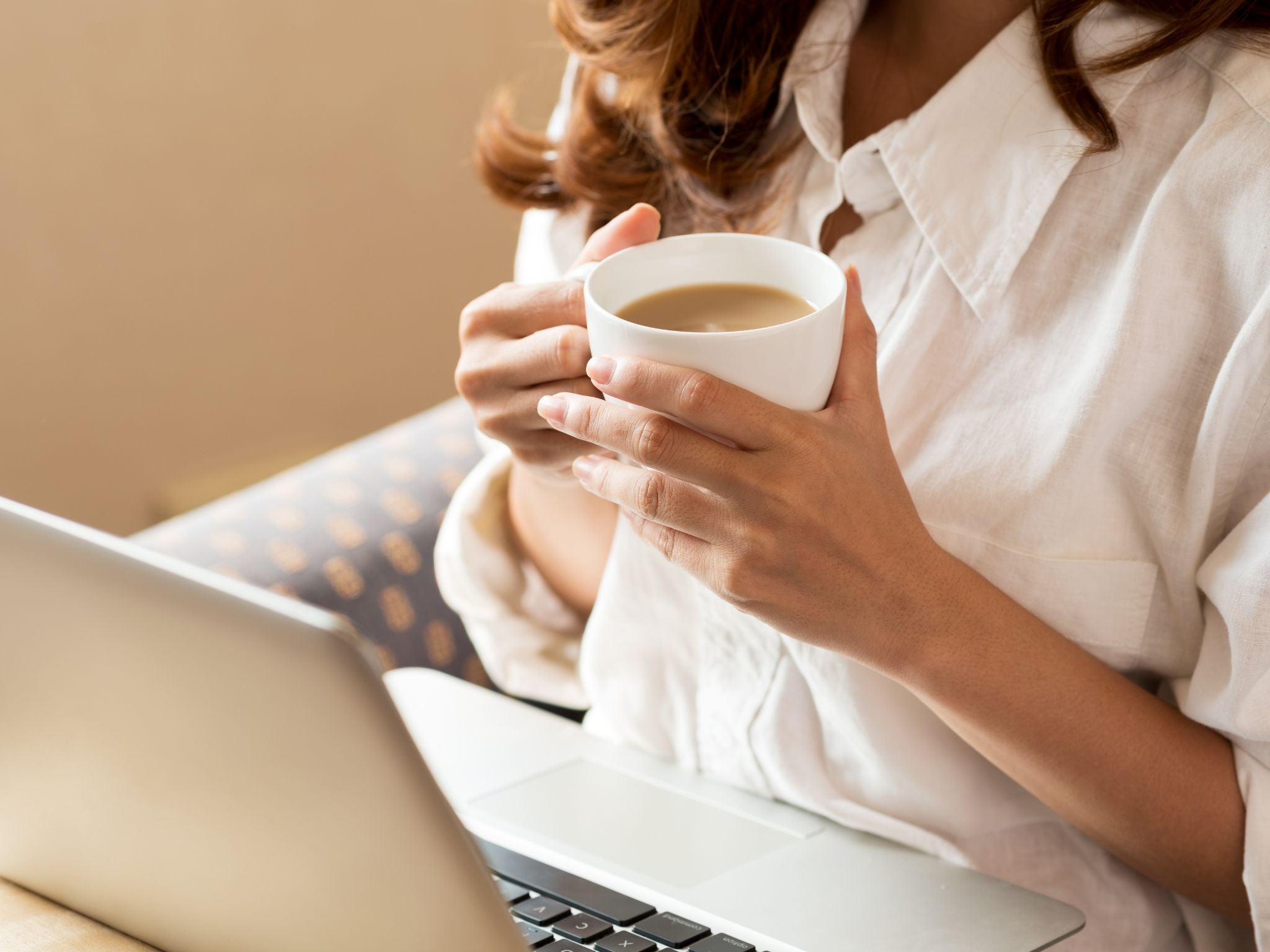 Woman with mug of coffee at desk