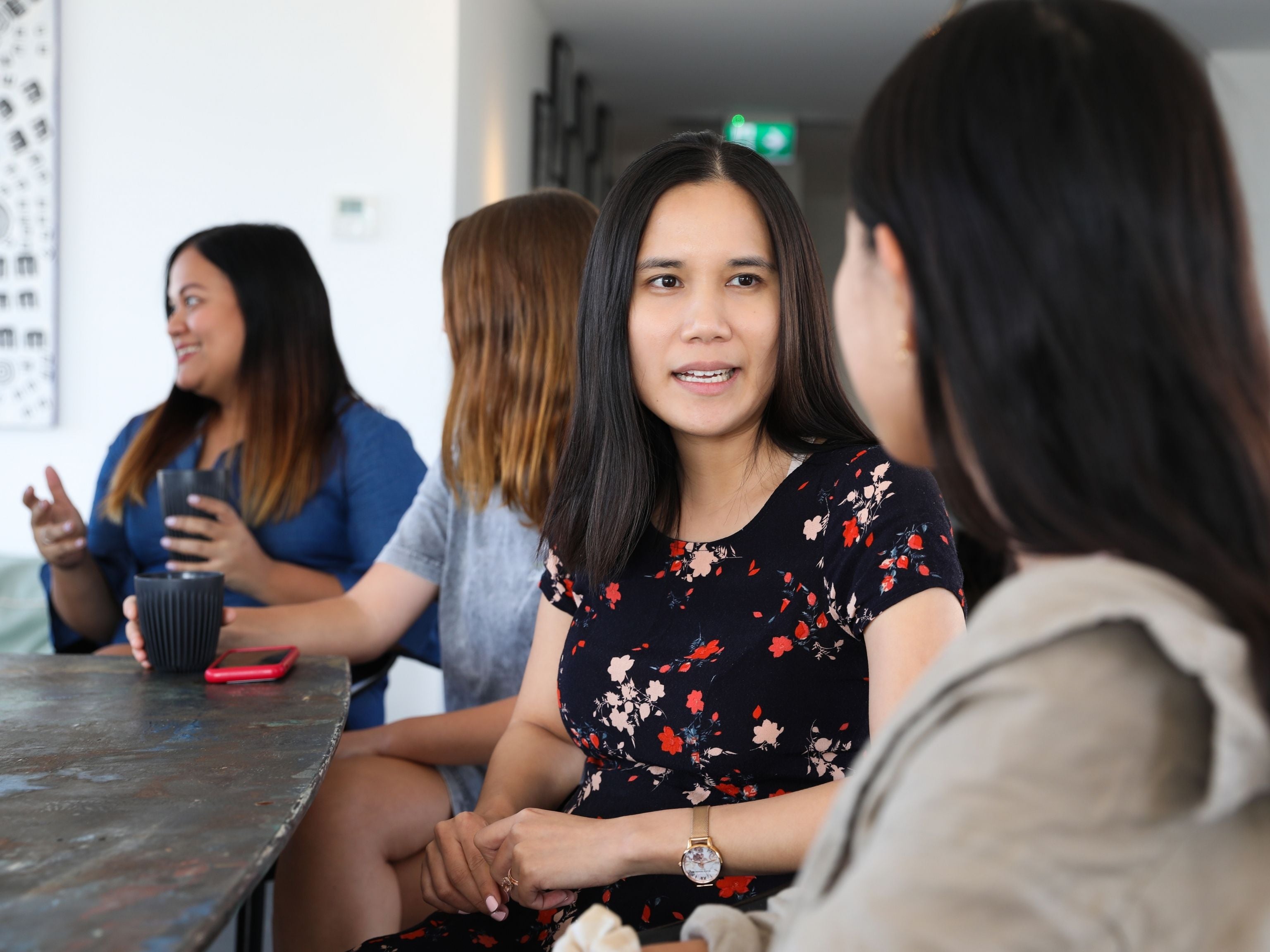 Women talking and drinking coffee during meeting