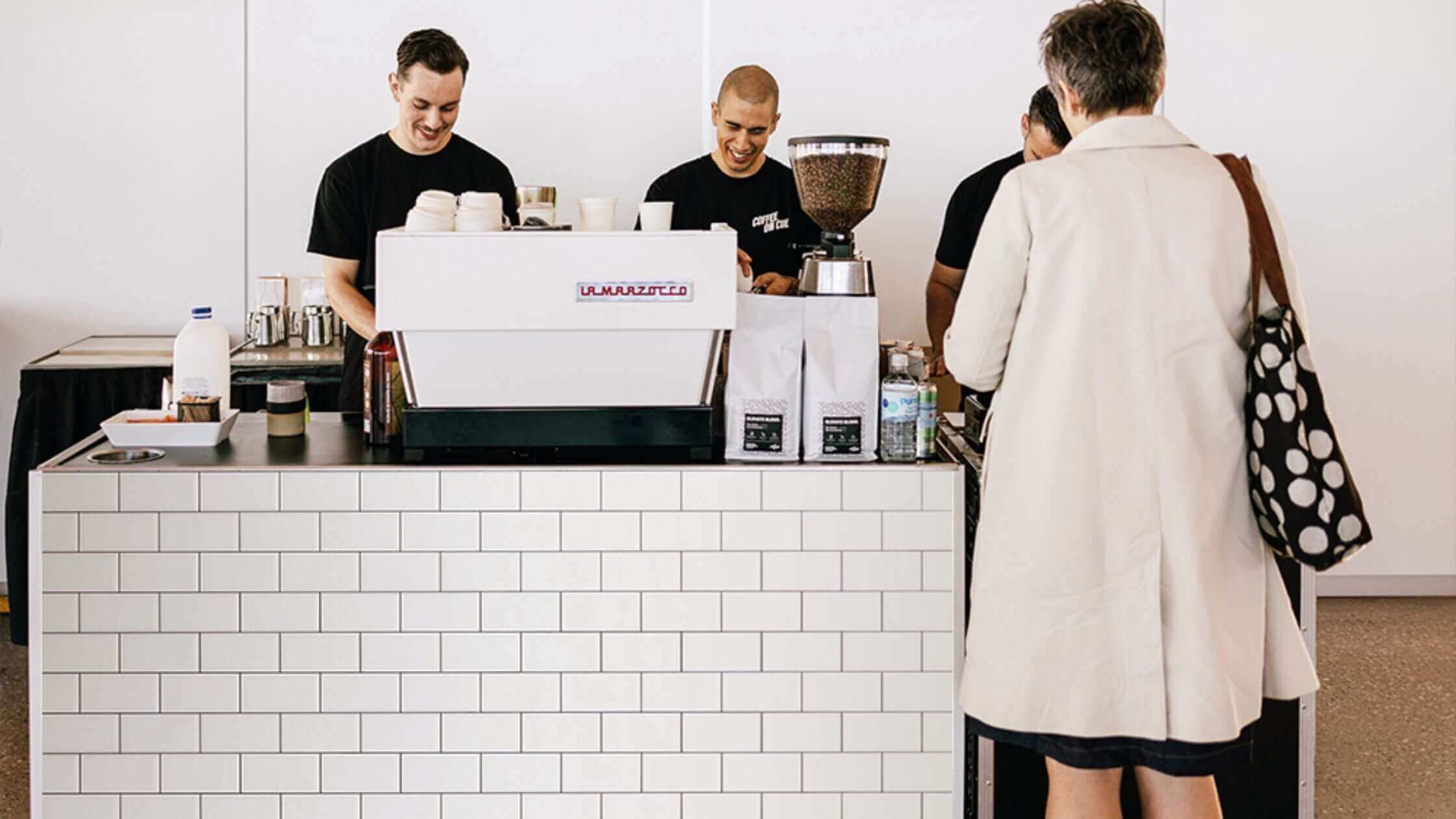 Coffee cart and baristas serving event guests