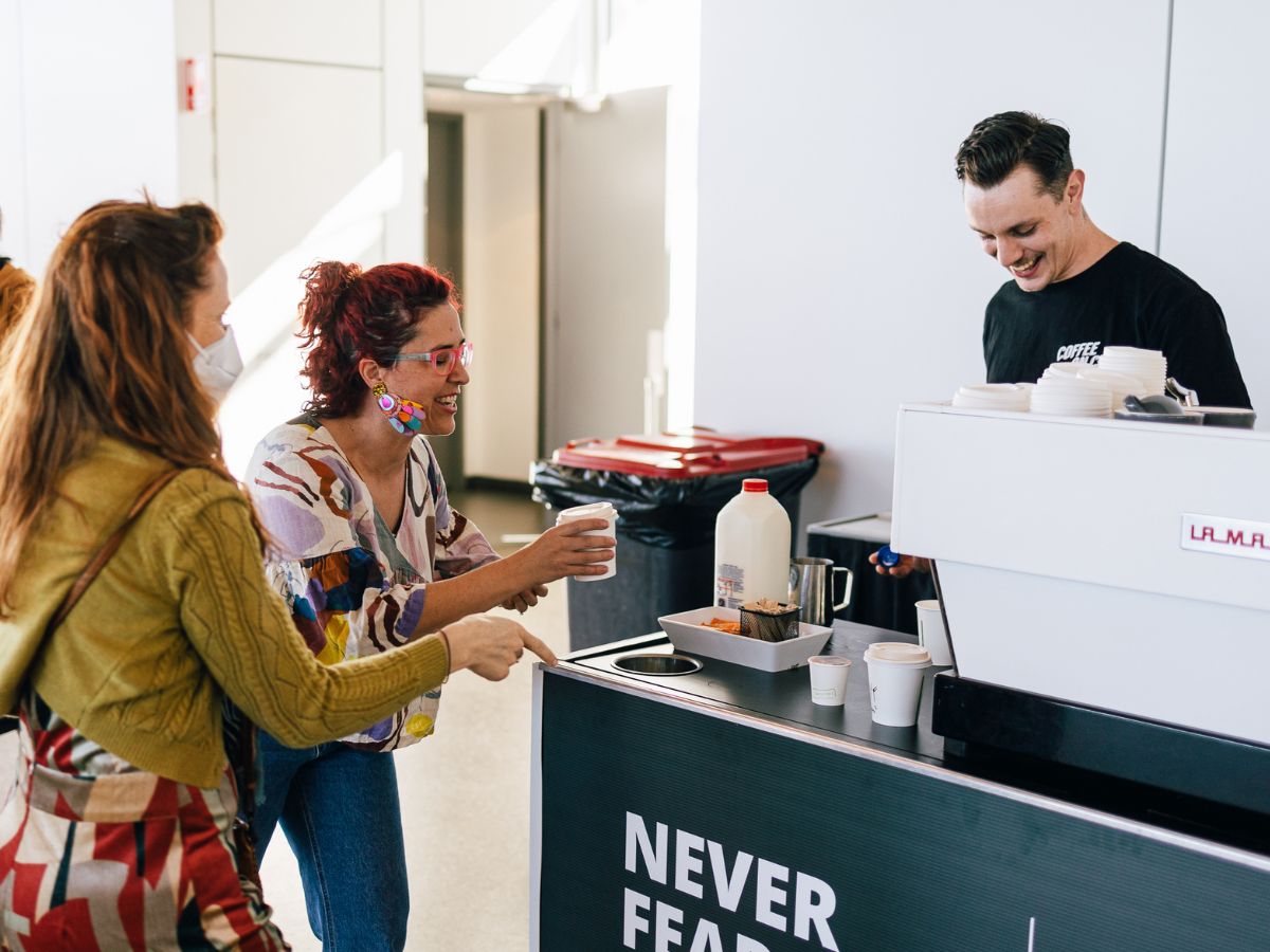 Barista handing coffees to event attendees