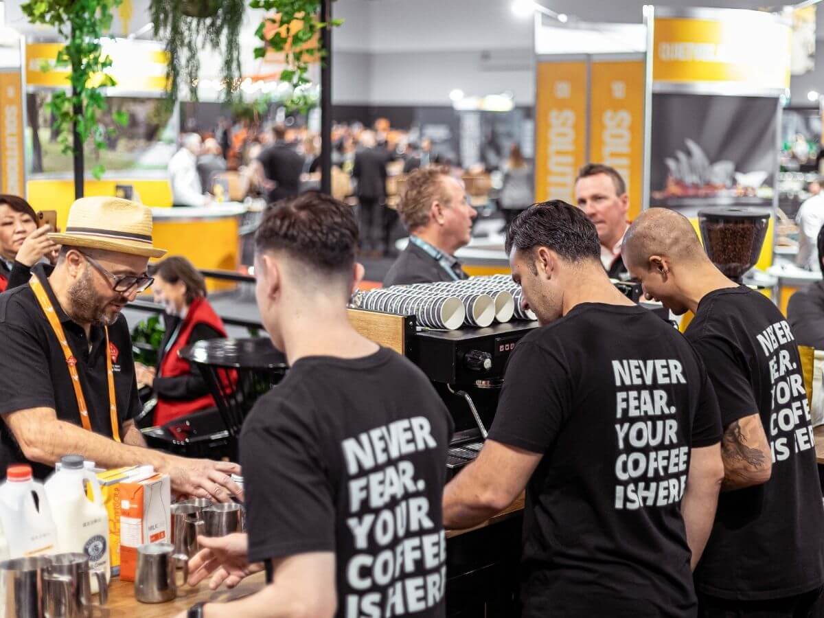 Three baristas making coffee at their tradestand