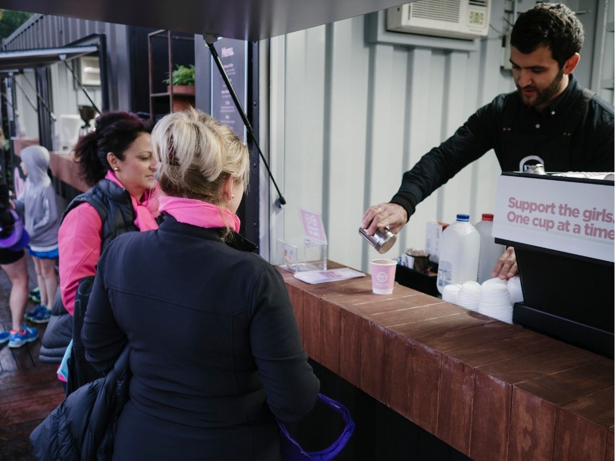 Barista handing coffee to event attendees