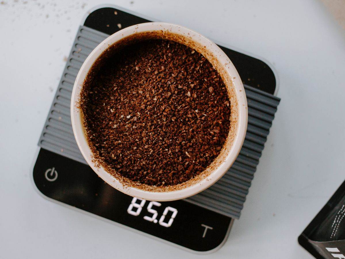 Coffee grounds in cup on scales