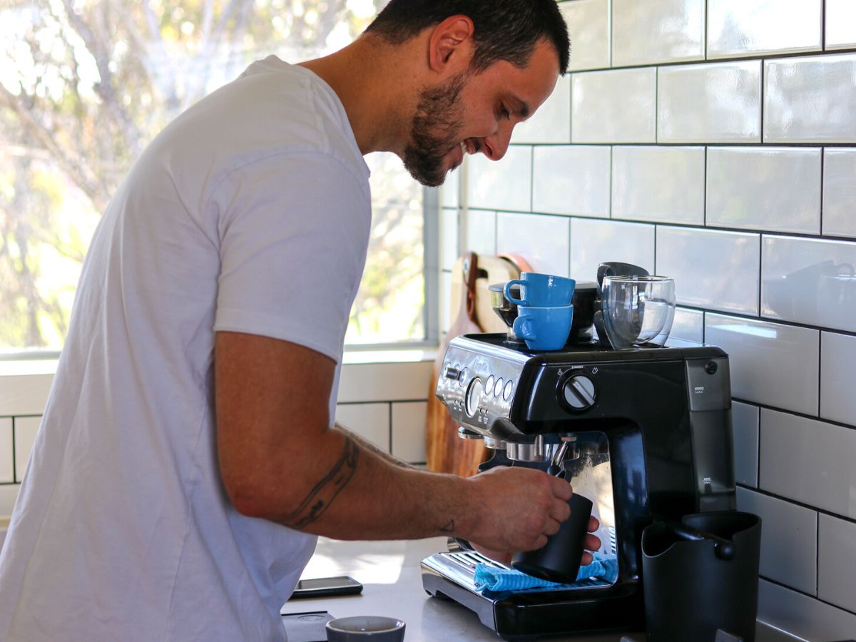 Man steaming milk on home espresso machine