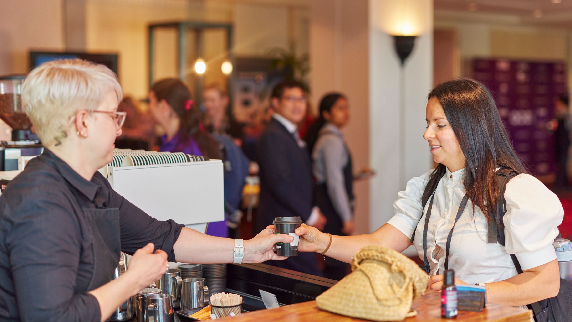 Tourism NZ barista on stand serving coffee to event guest