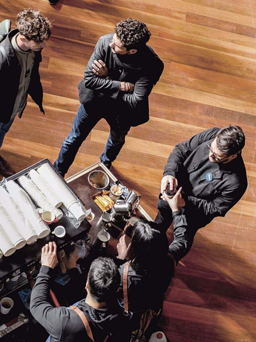 Two coffee cart baristas making and serving conference guests