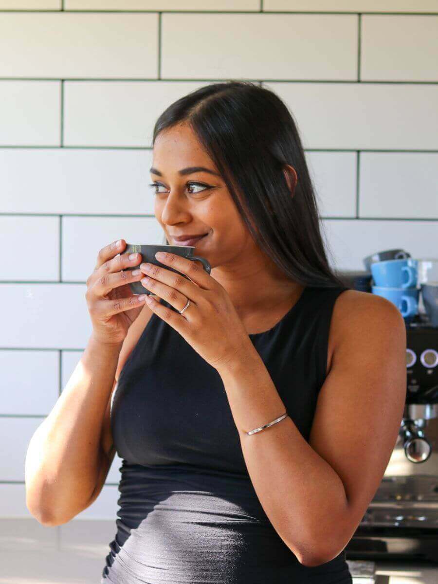 Woman drinking Coffee on Cue Elevate Blend at home