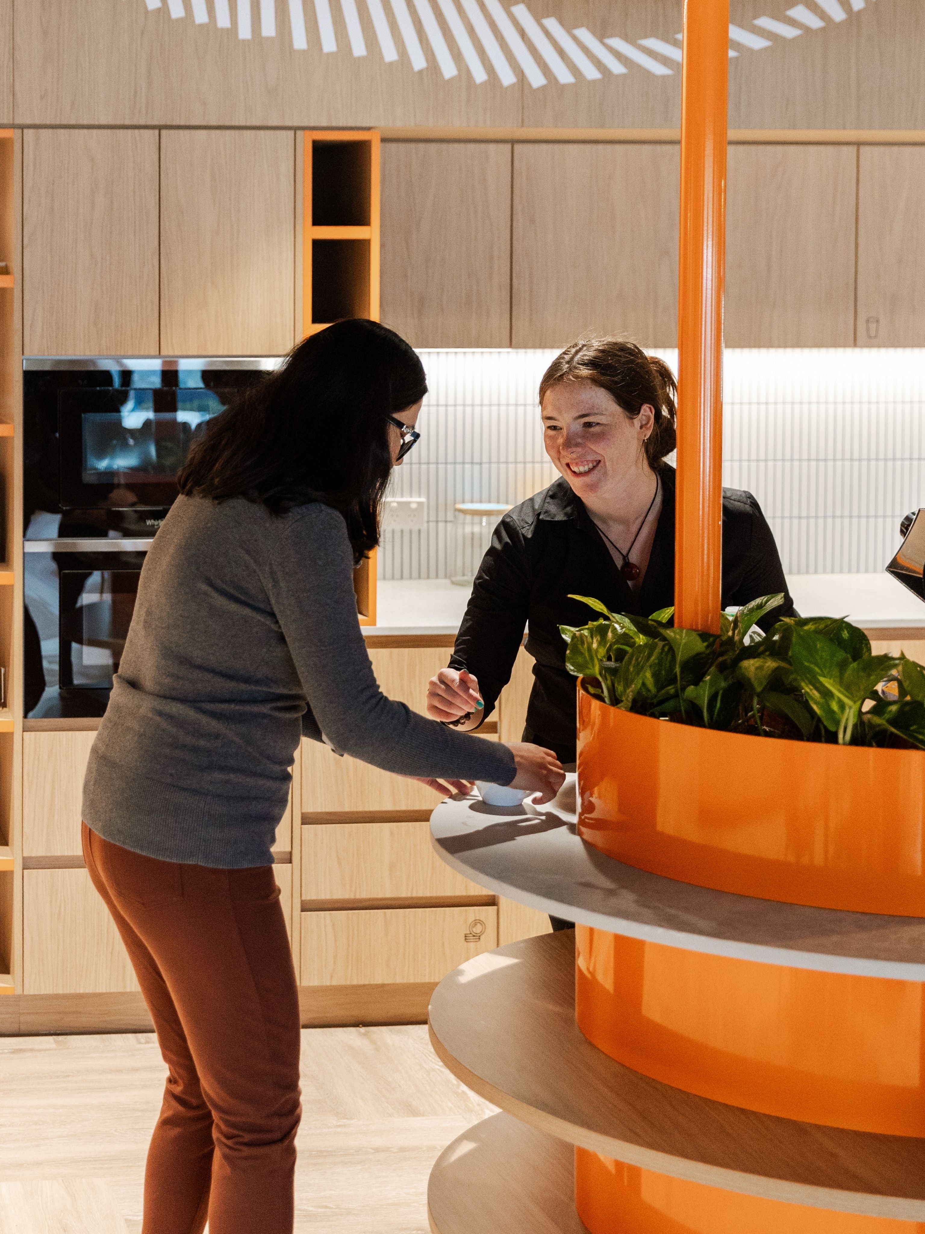 Workplace barista serving coffee to staff member