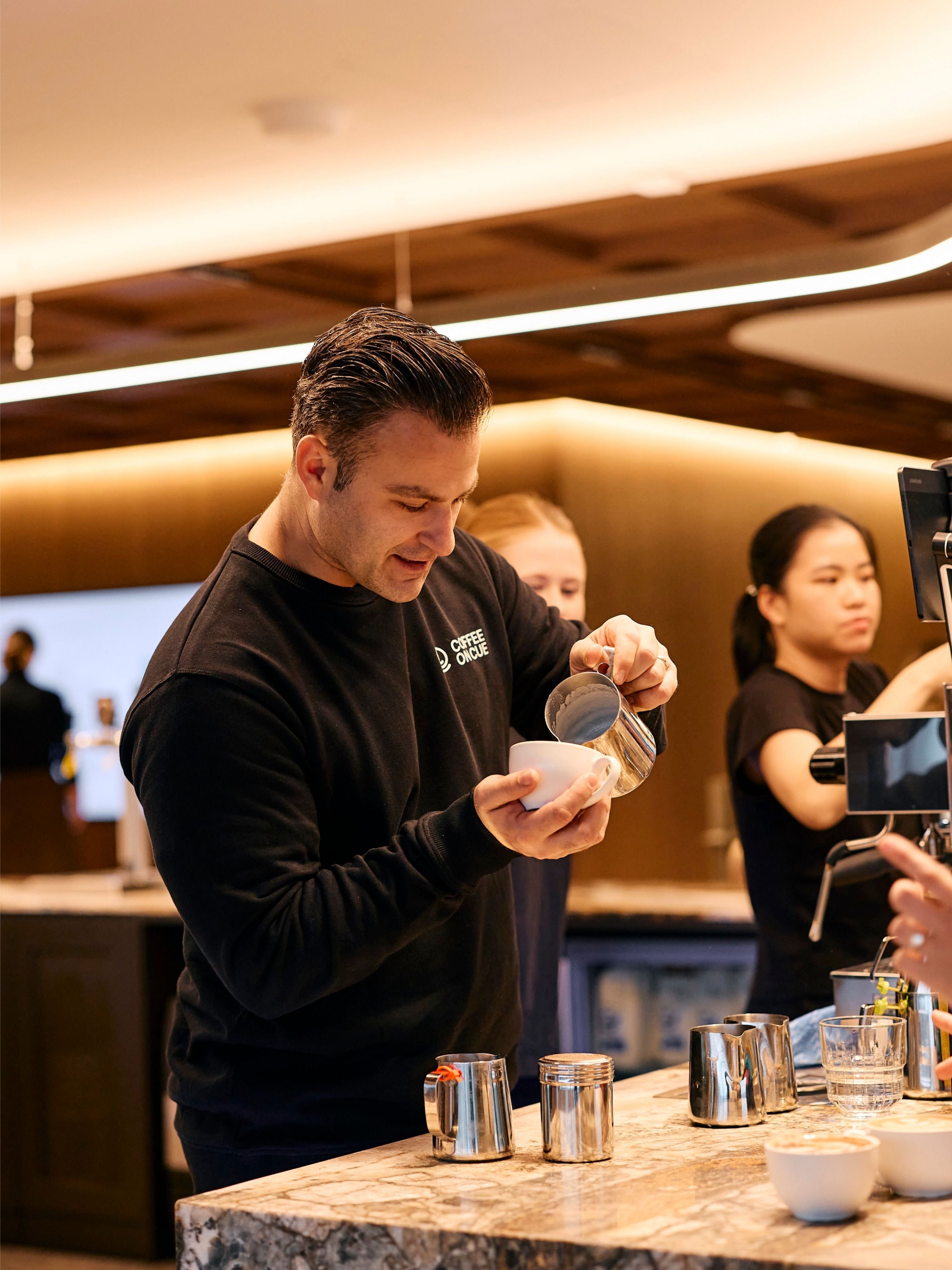 Ryan pouring a latte at the JLL workplace site