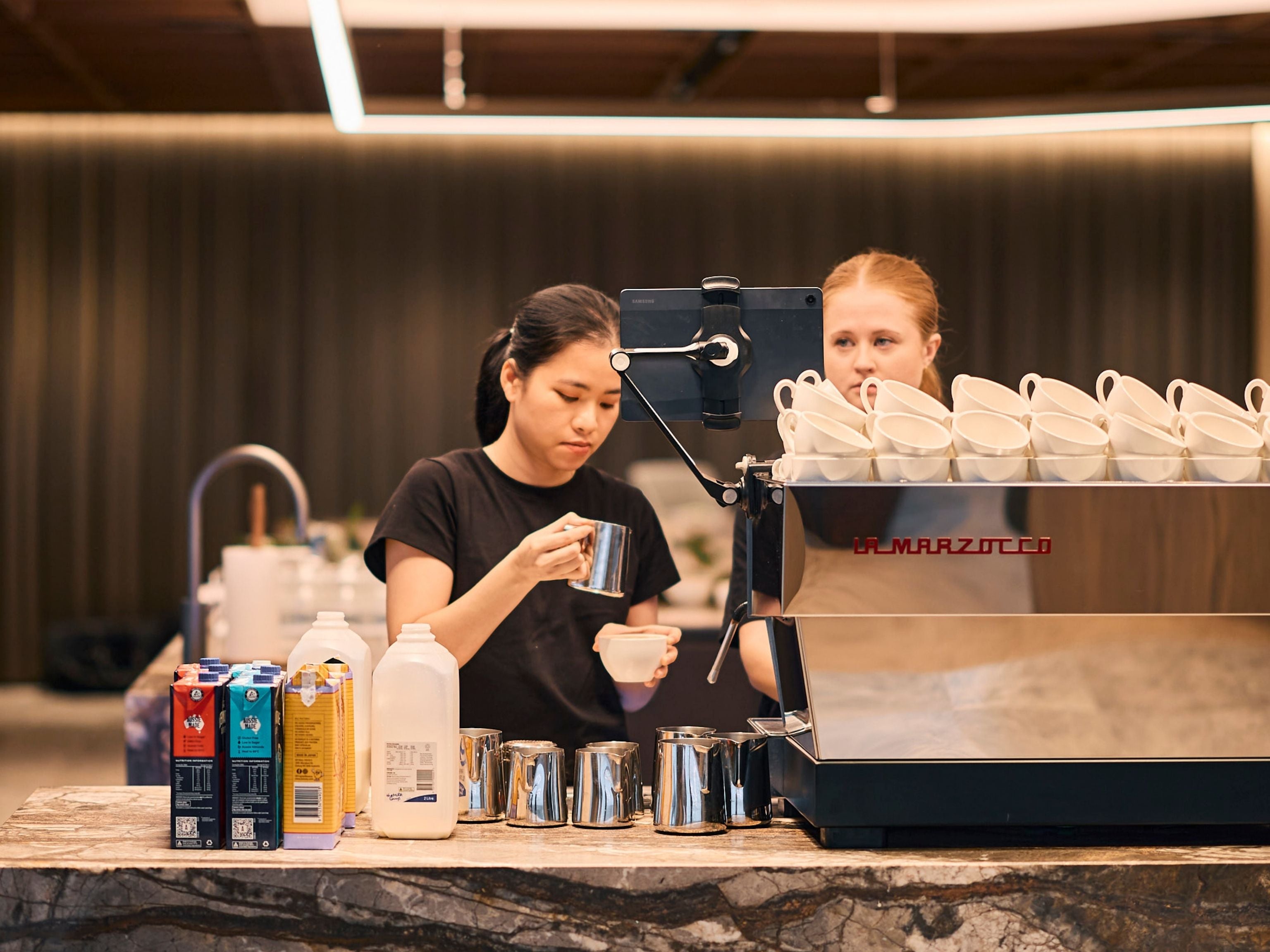 JLL baristas making coffee inside the workplace break out area
