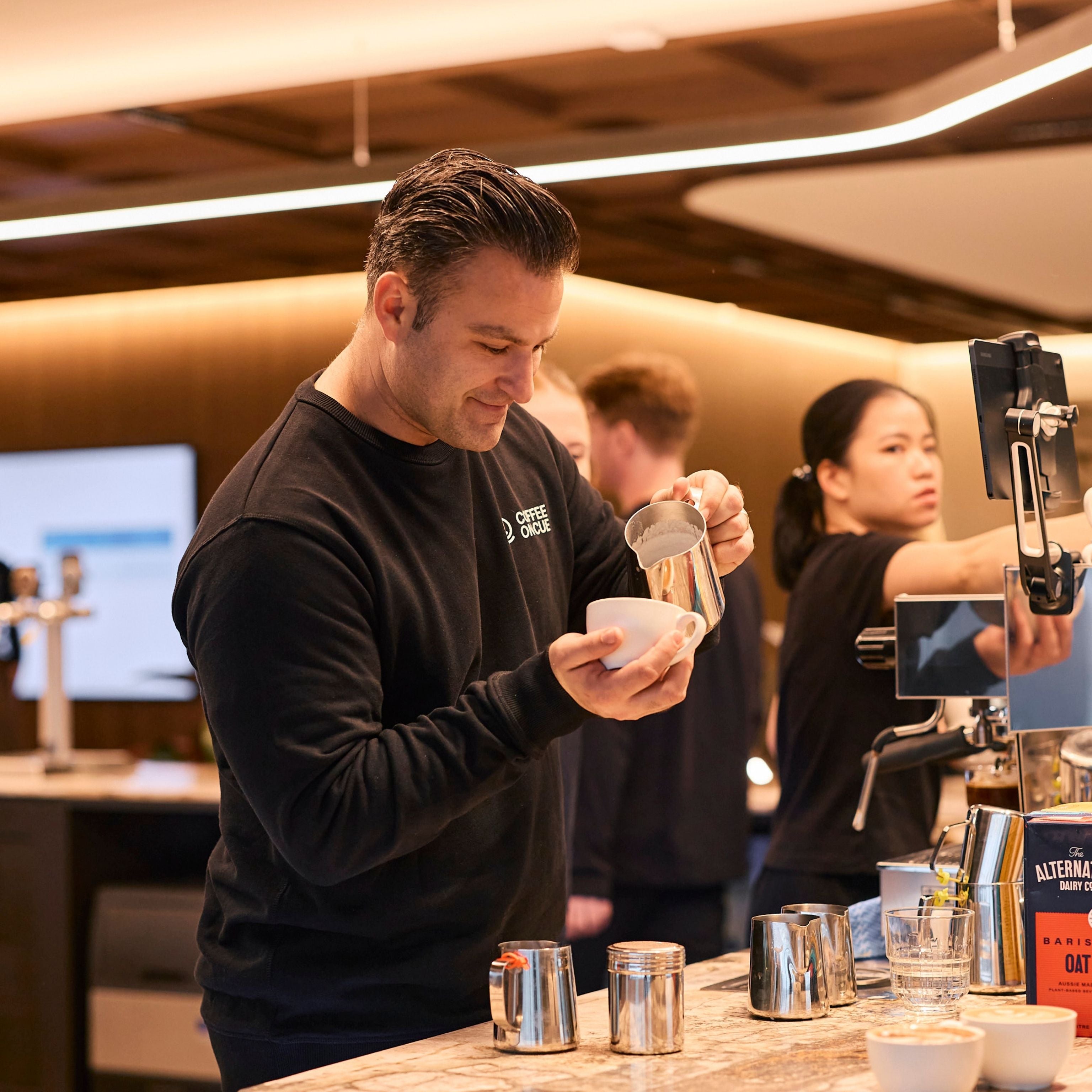 Workplace JLL head barista pouring latte coffee