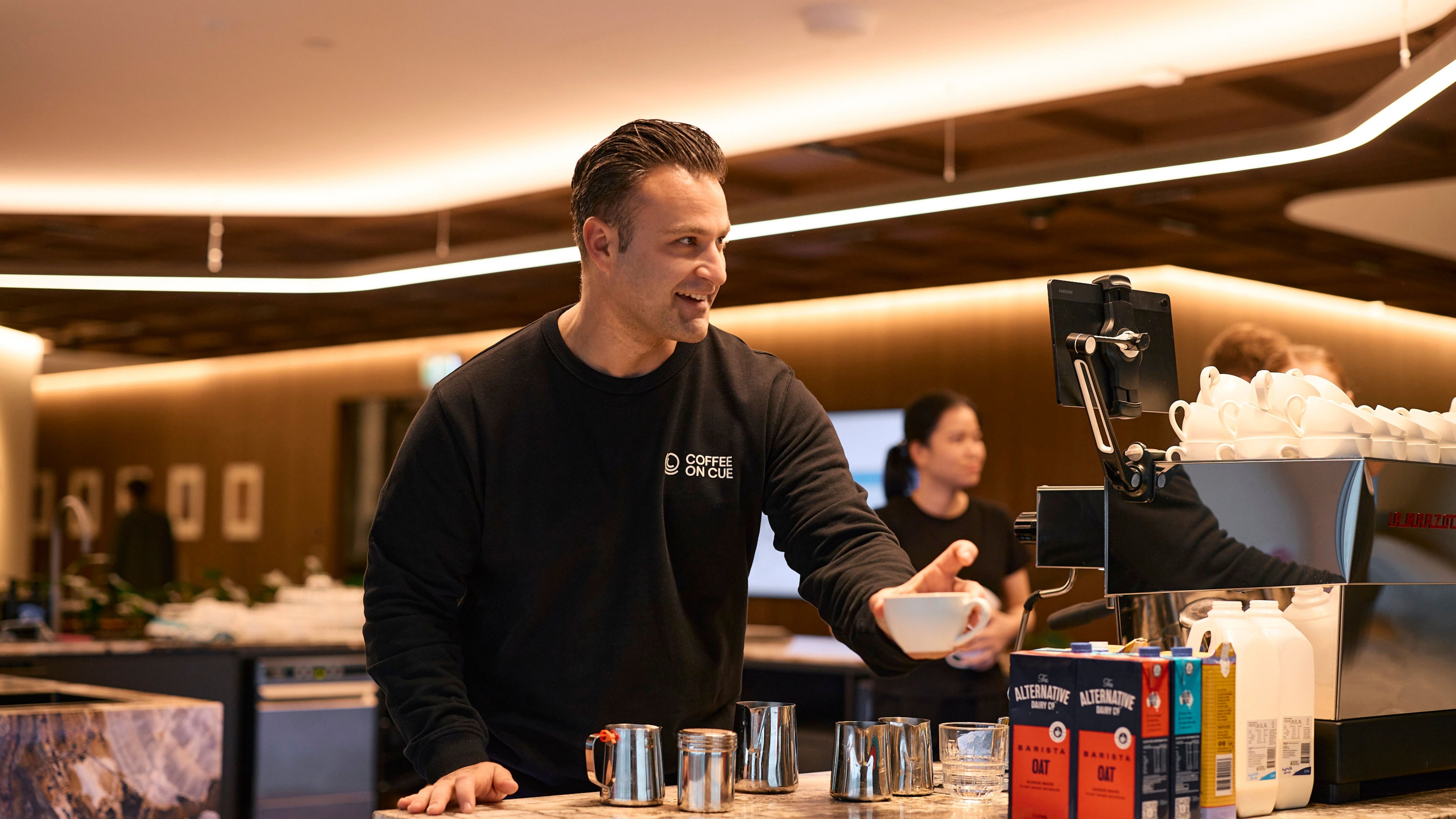 Ryan serving coffee at the JLL workplace cafe in Melbourne